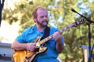 Guitarist in blue shirt plays his electric guitar during College Park JazzFest 2016